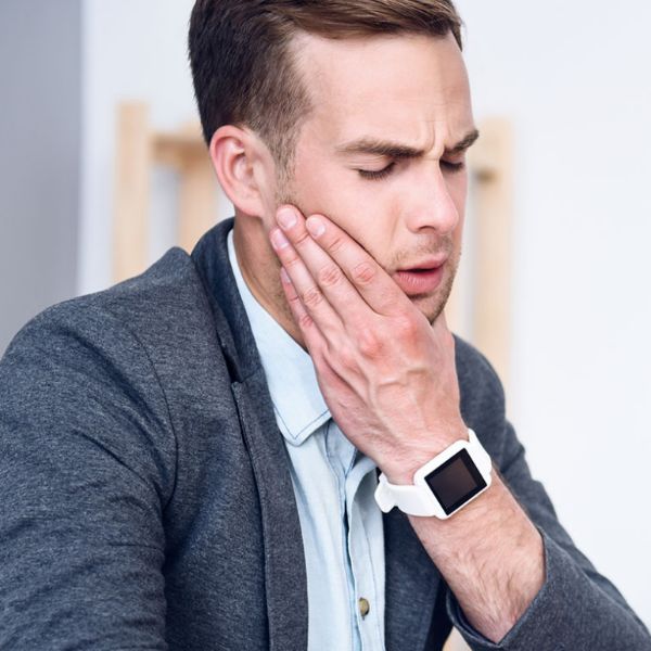 Man wearing smartwatch experiencing jawbone pain