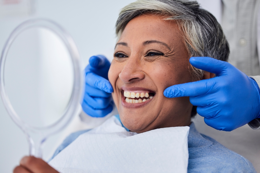 older woman sees smile in mirror
