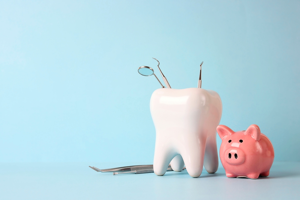 piggy bank next to dental tools