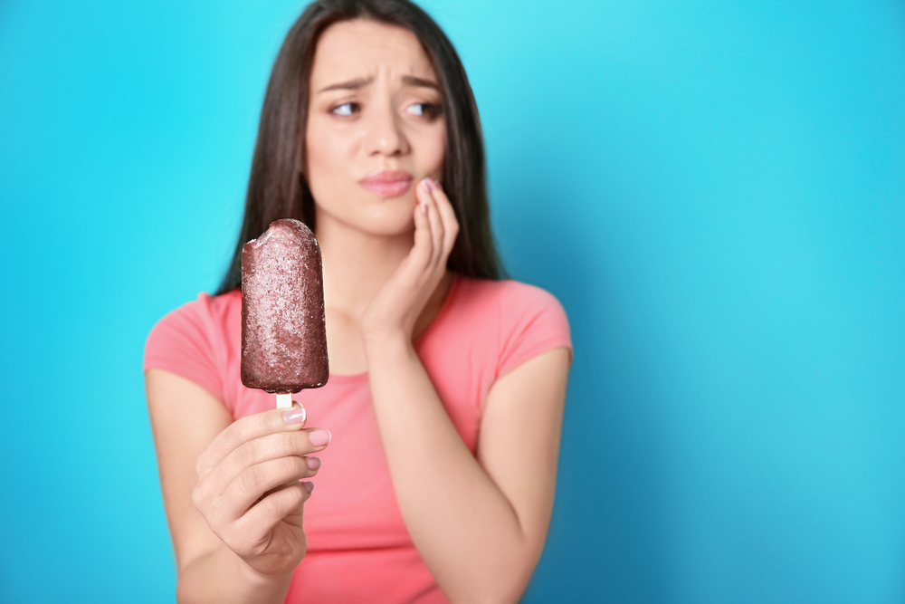 woman holding ice cream has tooth sensitivity