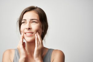 younger woman with tooth pain